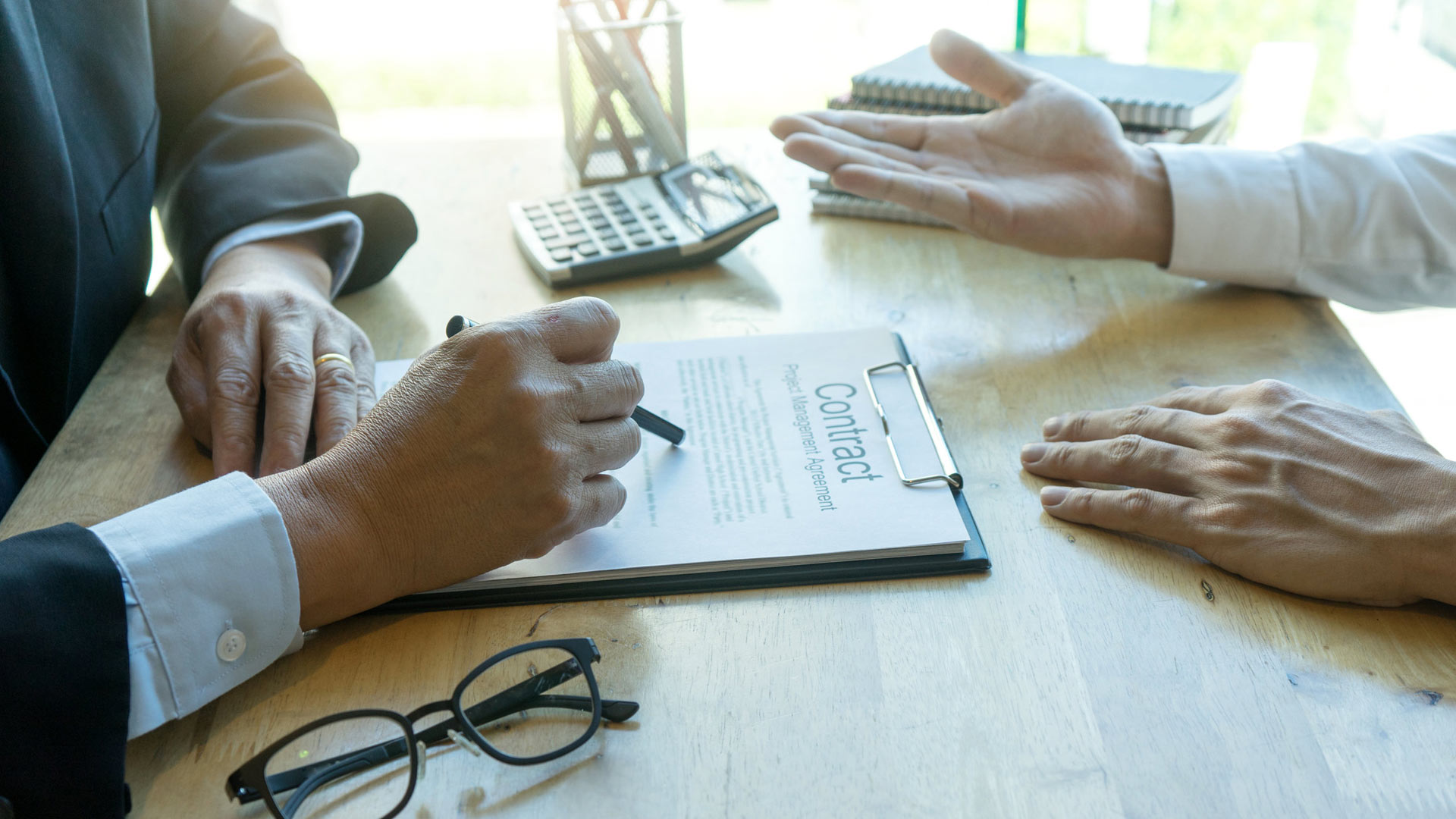 A lawyer and client reviewing a contract at a desk